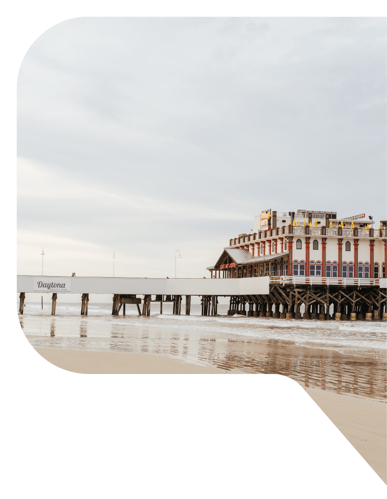 The two-story pier building at Daytona Beach, Florida overlooks the sandy beach.