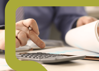 Close up of a hand using a calculator while a person reviews a document.
